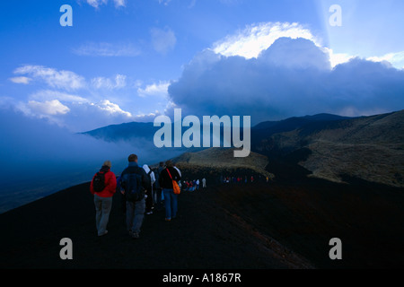 Touristen zu Fuß an den Hängen des Ätna bei Sonnenuntergang Sizilien Italien Europa EU Stockfoto