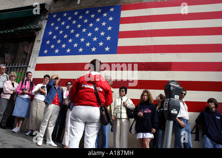 Ein Enthnically Diverse Reisegruppe vor einer großen amerikanischen Flagge, San Francisco, Kalifornien Stockfoto