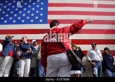 Ein Enthnically Diverse Reisegruppe vor einer großen amerikanischen Flagge, San Francisco, Kalifornien Stockfoto