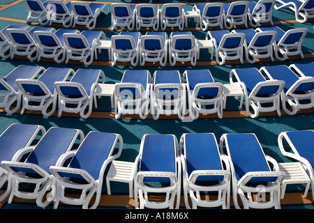 leere Liegestühle auf dem oberen Deck eines Kreuzfahrtschiffes angelegt Stockfoto