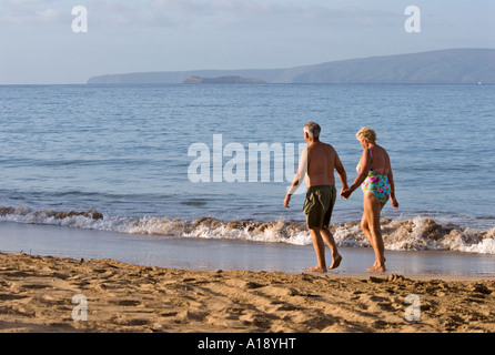 Älteres Paar zu Fuß am Strand von Maui, Hawaii Stockfoto