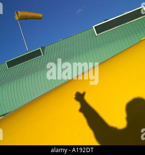 Windsack auf einem Dach gegen blauen Himmel mit einem männlichen Schatten in der Ecke Stockfoto