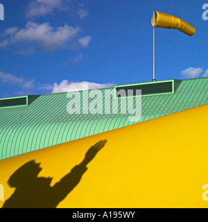 Windsack auf einem Dach gegen blauen Himmel mit einem männlichen Schatten in der Ecke Stockfoto