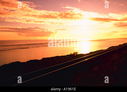 Eisenbahnschienen bei Sonnenuntergang entlang der Küste von Alaska Stockfoto