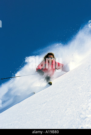 Weibliche Aktion Skifahrer drehen durch Tiefschnee Stockfoto