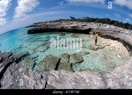 Turks Caicos Providenciales Provo blonde Frau in einem braunen Leopard Pareo Klettern auf Felsen in einer Bucht an der Nordwest-Punkt Stockfoto