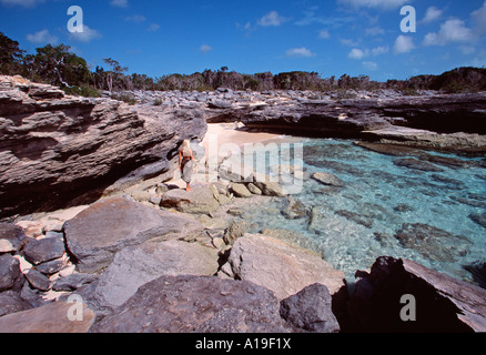 Turks Caicos Providenciales blonde Frau in einem braunen Leopard Pareo Klettern auf Felsen in einer Bucht an der Nordwest-Punkt Stockfoto