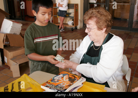 Miami Florida, Dade Public Library gebrauchte Buchverkauf, Shopping Shopper Shopper verkaufen, hispanische junge Jungen männliche Kinder Kinder kaufen zahlen kauft, Senior Stockfoto