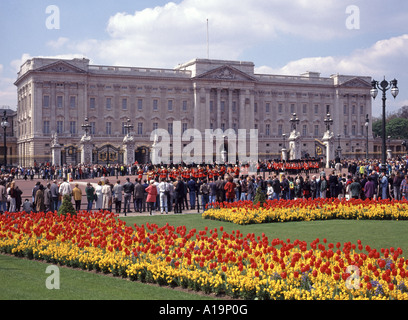 Frühling Anzeige der Tulpen mit Touristen entlang der Route und beobachten die Änderung der Guard Zeremonie im Buckingham Palace London England Großbritannien Stockfoto