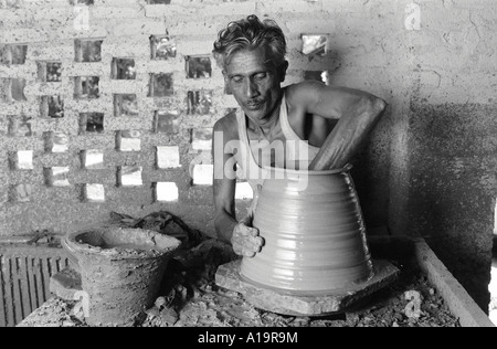 S/W eines Töpfers, der einen Topf auf einem Tretrad im ländlichen Tamil Nadu, Südindien dreht Stockfoto