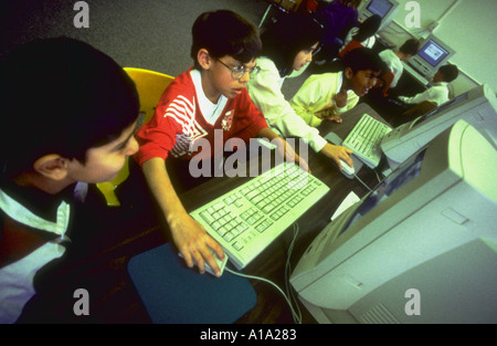 Vierte Klasse mehrere Schülerinnen und Schüler mit dem Computer im Computerraum der Schule Stockfoto