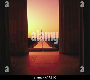 Blick auf das Washington Monument und das Reflexionsbecken durch die Säulen des Lincoln Memorial in der Abenddämmerung Washington DC Stockfoto