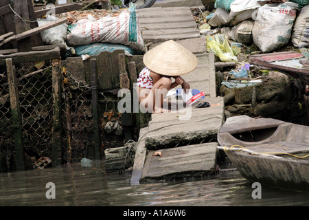 Kleines Mädchen mit dem Fluss Dock als eine Toilette, Mekong-Delta, Vietnam Stockfoto