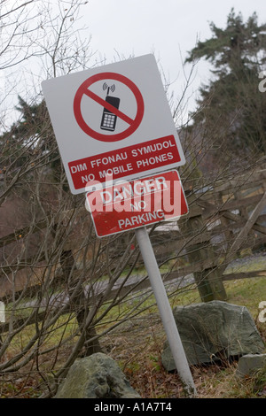 Zweisprachige Schilder, Walisisch und Englisch, keine Handys und Gefahr No Parking Stockfoto