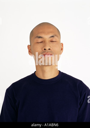 Junge asiatische Mann mit geschlossenen Augen Stockfoto