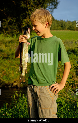 Junge, Eleven-Year-Old, hält einen Fisch-Hecht, dass er sich selbst gefangen Stockfoto