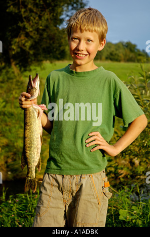 Junge, Eleven-Year-Old, hält stolz einen Fisch-Hecht, dass er sich selbst gefangen Stockfoto