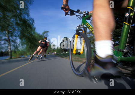 USA, Washington, Seattle, Mountain Biker entlang beschäftigt reitet trail umliegende Green Lake Park im Frühjahr (remote-Kamera) Stockfoto