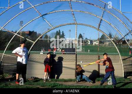 USA-Washington-Seattle-Boys spielen whiffle Ballspiel gegen Rücklaufsperre bei Teen Ligaspiel in Ballard auf Frühling Nachmittag Stockfoto