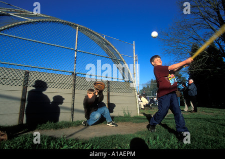 USA-Washington-Seattle-Boys spielen whiffle Ballspiel gegen Rücklaufsperre bei Teen Ligaspiel in Ballard auf Frühling Nachmittag Stockfoto