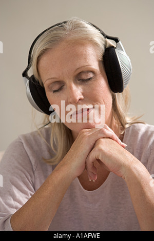 Reife Frau mit Kopfhörern Stockfoto