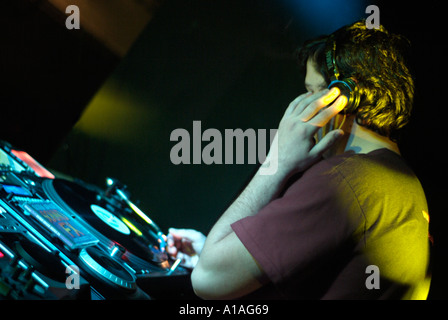 Club DJ hinter den Decks ein Nachtclub-Cutting in einer Spur auf einer Drehscheibe Stockfoto