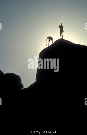 USA Kalifornien Joshua Tree National Park Kletterer auf Sandstein Gipfeln bei Sonnenuntergang in Mojave-Wüste Stockfoto