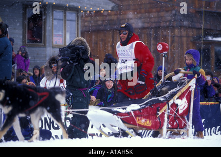 USA Alaska 1998 Iditarod Champion Jeff King läuft mit Hundegespann nach unten Front Street in Richtung Ziellinie in Nome Stockfoto