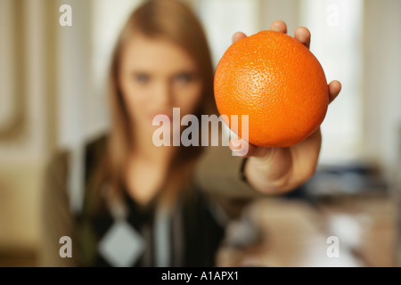 Frau hält eine orange Stockfoto