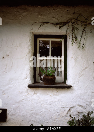 alte Metall Kessel sitzt auf dem Fenster einer alten strohgedeckten Wohnung in der irischen Landschaft, Stockfoto