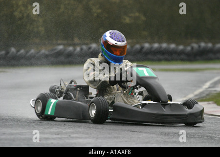 World Formula Kartfahrer wirft Spray und Hahn Schwänzen bei einem nassen Nutts Ecke Motorsport Circuit County Antrim Stockfoto