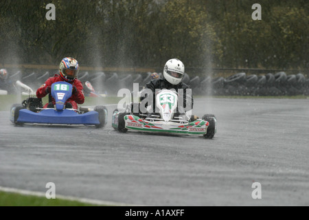 zwei World Formula Kart Fahrer werfen Spray und Hahn Schwänzen bei einem nassen Nutts Ecke Motorsport Circuit County Antrim Stockfoto