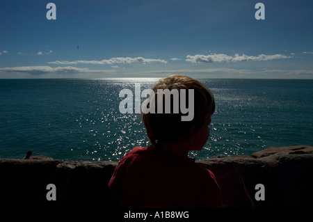 eine Rückansicht Schuss jungen Blick auf Deich über ruhigen Mittelmeer Stockfoto