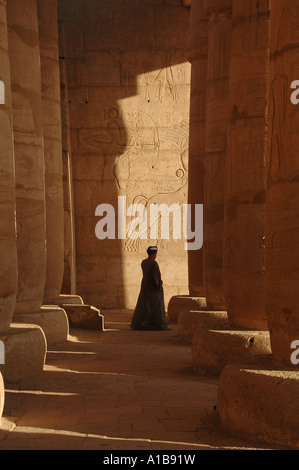 Ägyptischer Mann steht inmitten Osiride Spalten am Ramesseum Leichenhalle Tempel von Ramesses II auf dem Westufer des Nil in Luxor Ägypten Stockfoto