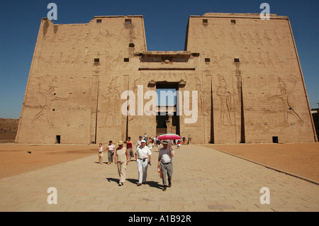 Touristen zu Fuß außerhalb Edfu alten ägyptischen Tempel, der dem Falkengott Horus geweiht, in ptolemäischer Zeit zwischen 237 und 57 v. Chr., Ägypten gebaut Stockfoto