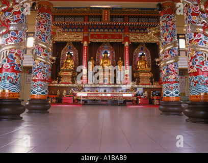 Drei riesige Statuen des Buddha aus Teakholz bedeckt mit Goldfolie und Drachen umschlungen Säulen im Inneren der Puu Jih Shih Tempel Sandakan Stockfoto
