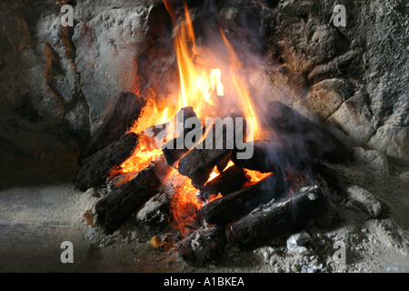 Flammen, die aus einem brennenden Torf Torffeuer in einem traditionellen irischen Reetdachhaus Rost County Down Northern Ireland Stockfoto