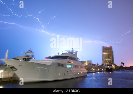 Ein Blitz Blitz Streifen über den Abendhimmel über eine Luxus-Megayacht angedockt in Fort Lauderdale, Florida USA. Stockfoto