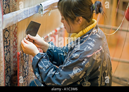 CHINA XI weibliche chinesische Handwerker eine orientalische Wolldecke auf einem vertikalen Webstuhl weben Stockfoto