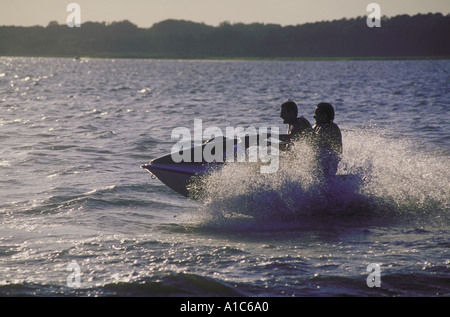 Zwei junge Männer, die eine aufregende Fahrt auf einem Jetboot PWC auch bekannt als jet-Ski oder waverunners Stockfoto