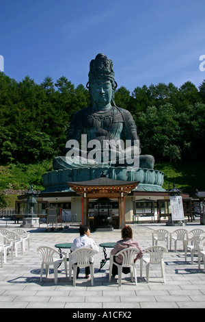 Zwei Frauen reden vor Showa Daibutsu, die größte Outdoor-Buddha in Japan, Aomori City. Stockfoto