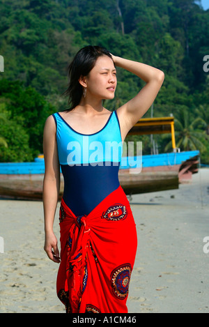 Junge Frau im Badeanzug und Sarong Spaziergänge am Strand Pulau Pangkor Insel Malaysia Stockfoto
