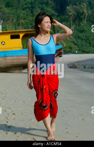 Junge Frau im Badeanzug und Sarong Spaziergänge am Strand Pulau Pangkor Insel Malaysia Stockfoto