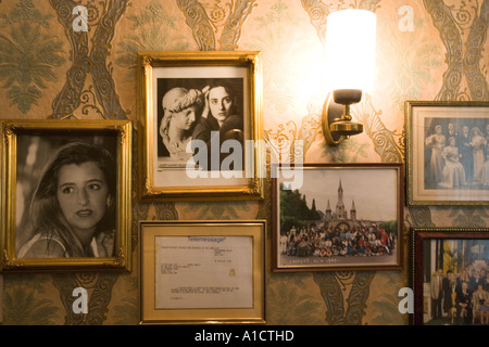 Stillleben mit gerahmten Fotografien an der Wand zusammen mit einer leuchtenden Lampe aufgehängt Stockfoto