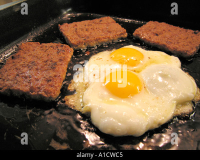 In Scheiben geschnittene Würstchen und Eiern in Pfanne braten Stockfoto