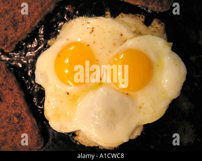 In Scheiben geschnittene Würstchen und Eiern in Pfanne braten Stockfoto