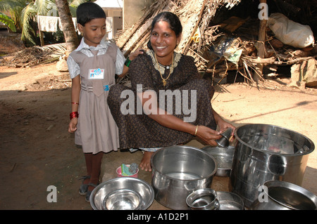 Eine blinde Mutter wäscht die Kochtöpfen vor ihrem Haus in Südindien Tamil Nadu Stockfoto