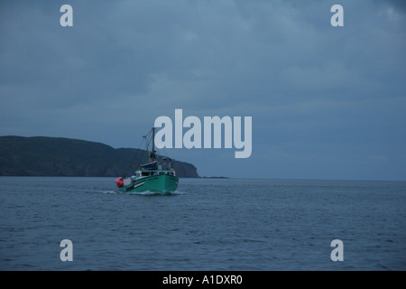 Ein Fischerboot kehrt zum Harbour Breton im Morgengrauen zurück. Stockfoto