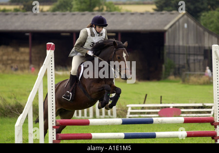 Junge Frau Bucht Ponyreiten über Showjump beim Pferd Studien Eventing Wettbewerb Gloucestershire Vereinigtes Königreich Stockfoto