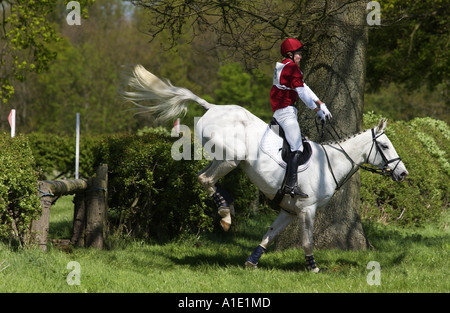 Junger Mann reitet auf einem grauen Stute Pferd in einem Langlauf-Vielseitigkeits-Wettbewerb Oxfordshire, Vereinigtes Königreich Stockfoto